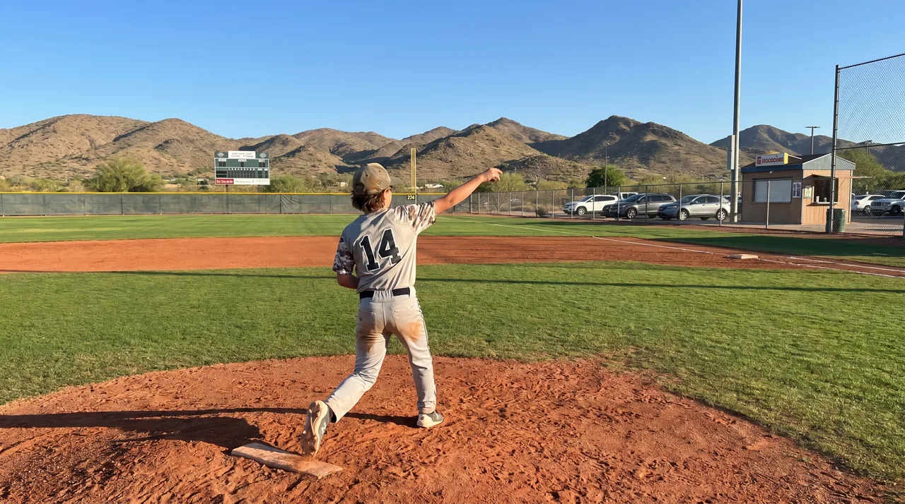 Baseball player in mid pitching motion on a sunlit field near Las Vegas
