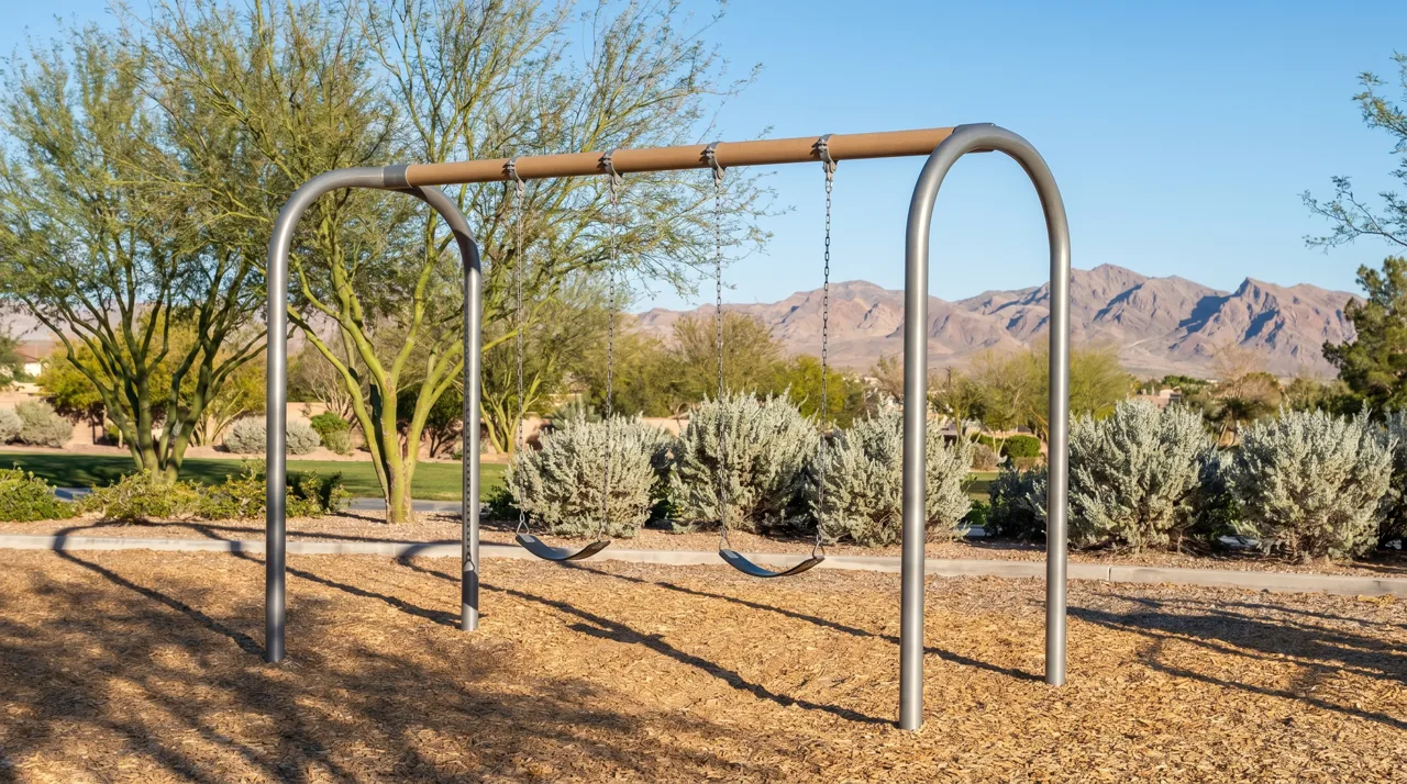 Empty modern playground swing set in a Las Vegas community park under afternoon sun