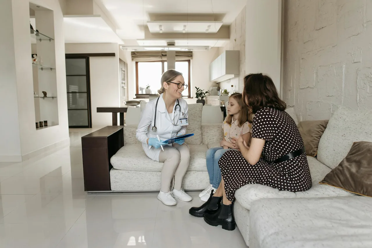 A family medicine doctor speaking with parents and their child in a clean exam room