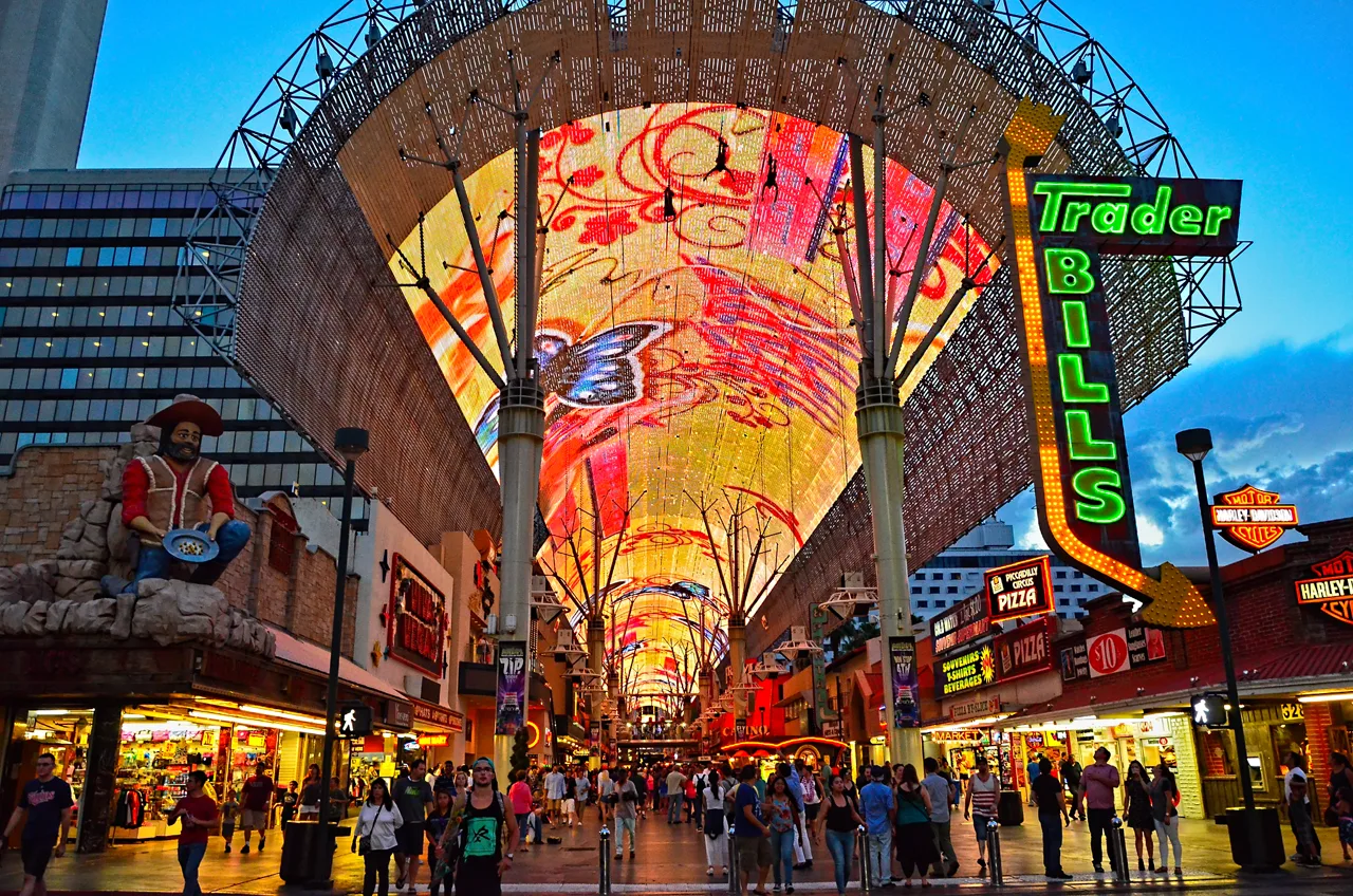 Pedestrians walking under the Fremont Street Experience LED canopy in Downtown Las Vegas at dusk