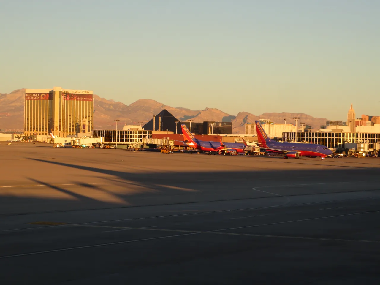 Harry Reid International Airport exterior with palm trees and the Las Vegas Strip skyline in the background