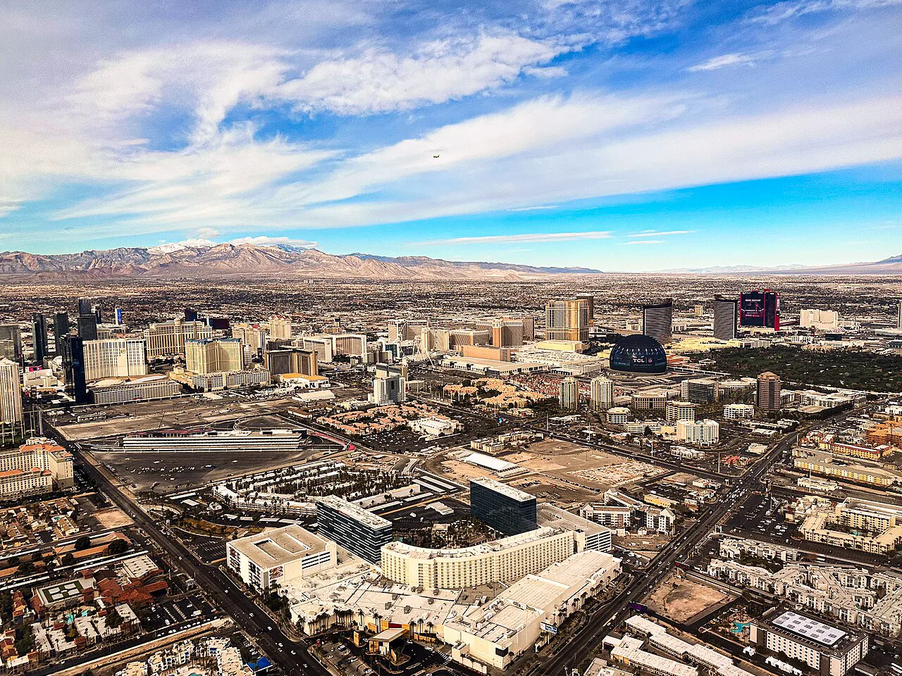 Aerial view of the Las Vegas Strip at dusk with the Sphere illuminated to the east