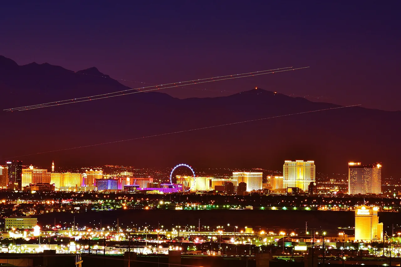 Las Vegas Strip skyline at night viewed from an elevated hillside vantage with city lights spread below