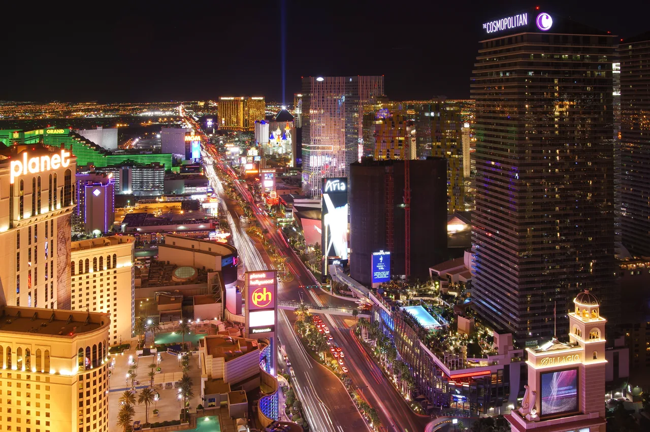 Las Vegas Strip skyline illuminated at night with high-rise condo towers in the foreground