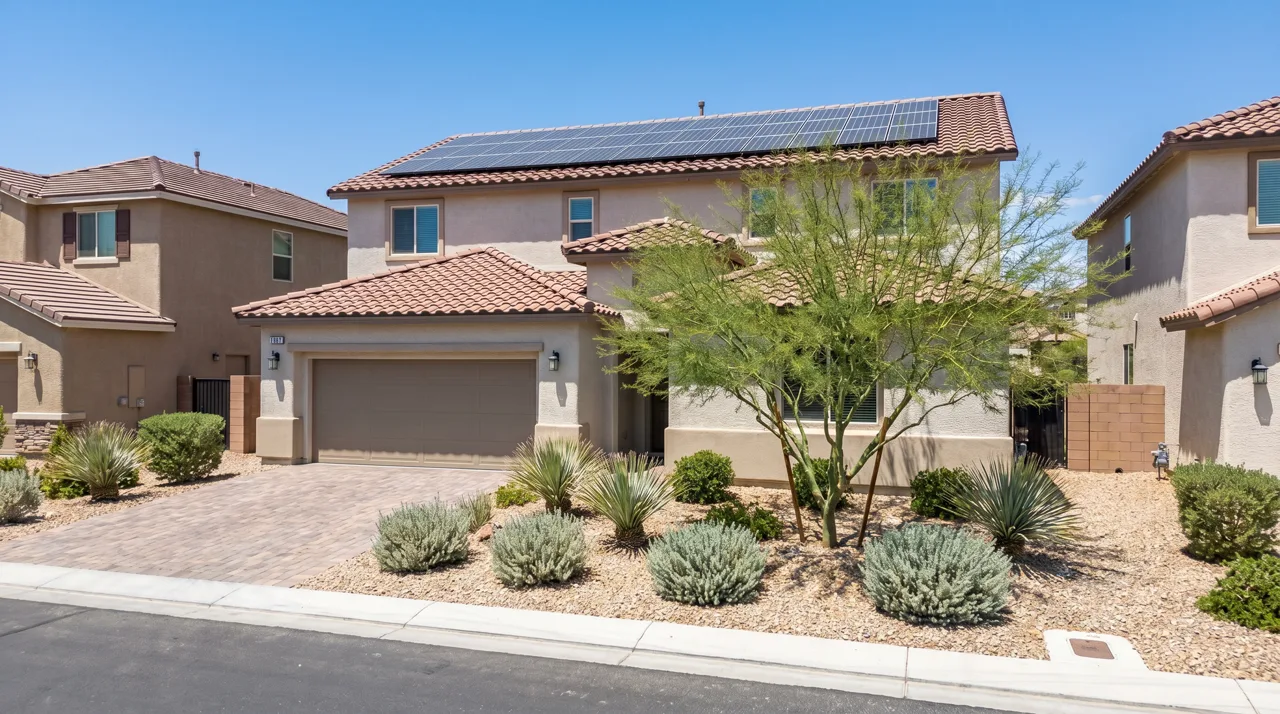 Modern Las Vegas home with rooftop solar panels and desert-friendly xeriscaping in the front yard