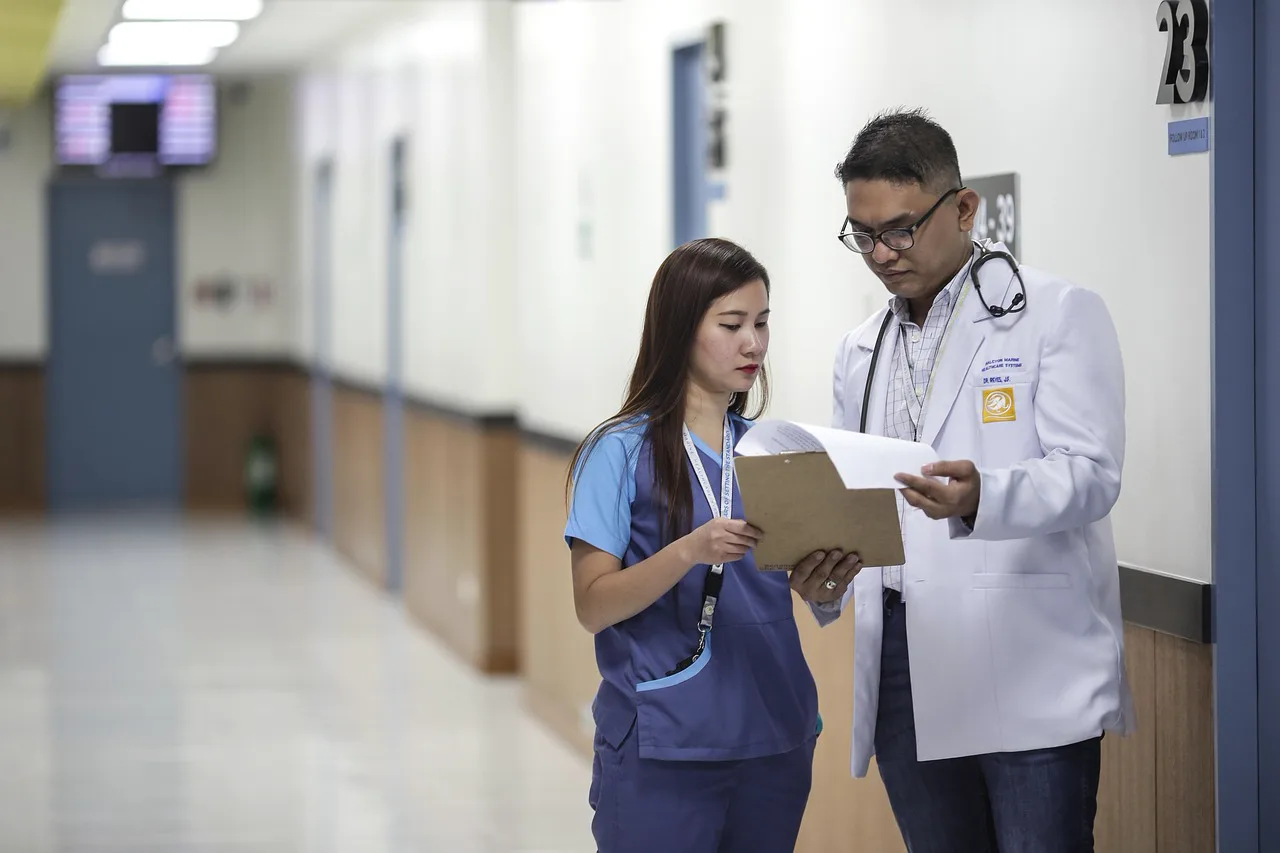Nurse working in a modern hospital hallway with medical equipment