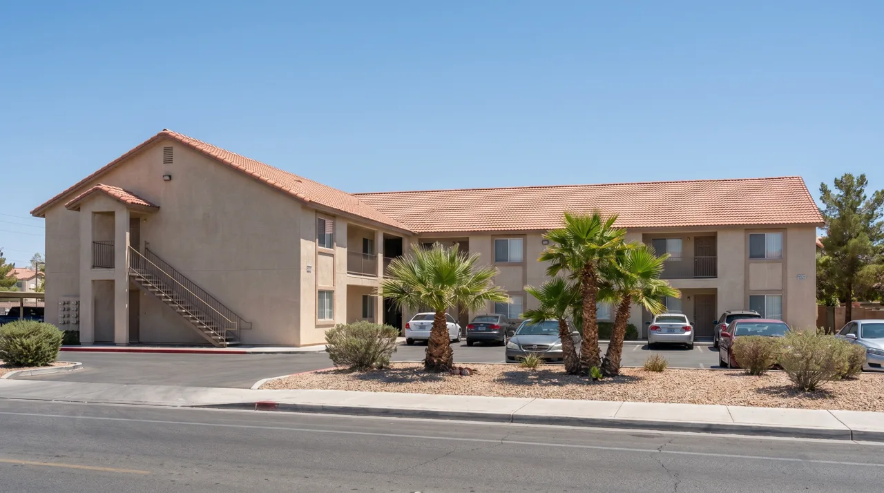 Small two-story Las Vegas apartment building with palm trees and desert landscaping out front