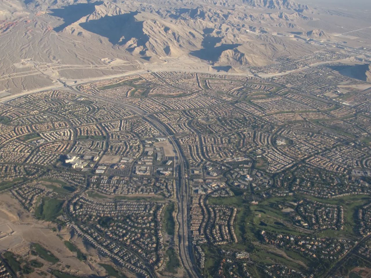 Aerial view of a Summerlin residential neighborhood with red tile roofs and distant mountains